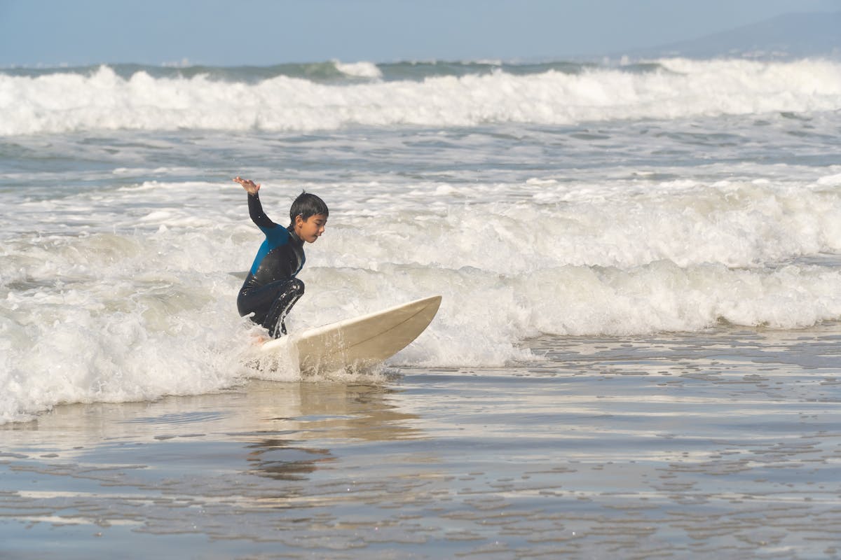Boy riding a surfboard in the whitewater waves