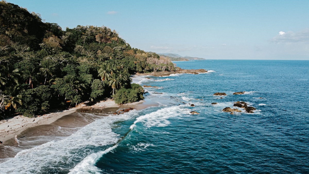 Aerial view of a lush Costa Rica coastline with turquoise water and tropical forest
