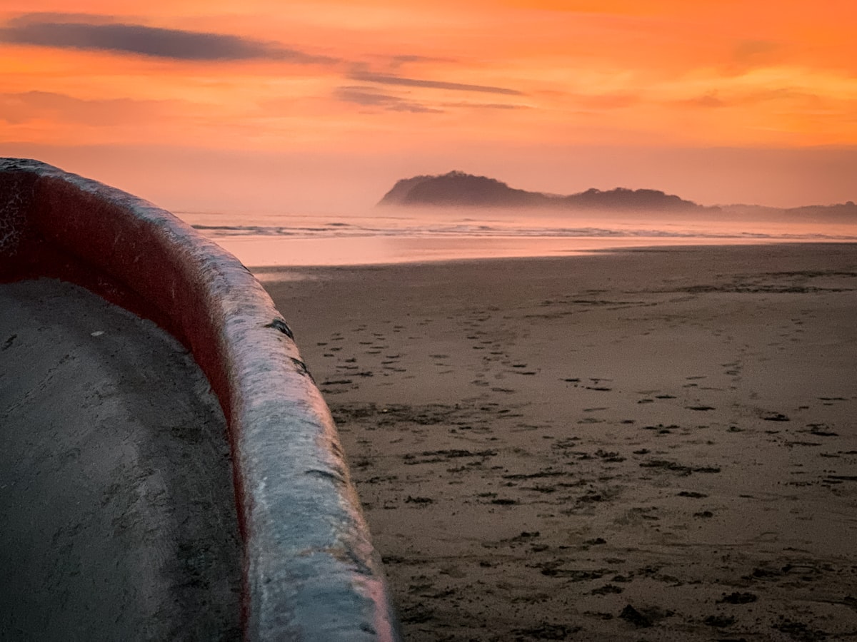Golden sunset over a Costa Rica beach with a surfer silhouette walking along the shore
