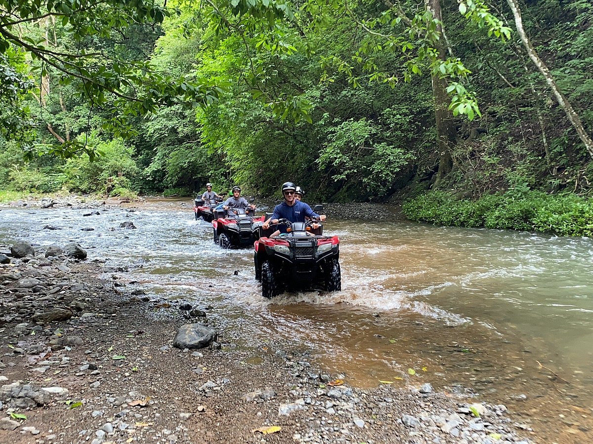 Rider on an ATV cruising along a rocky beach in Nosara, Costa Rica