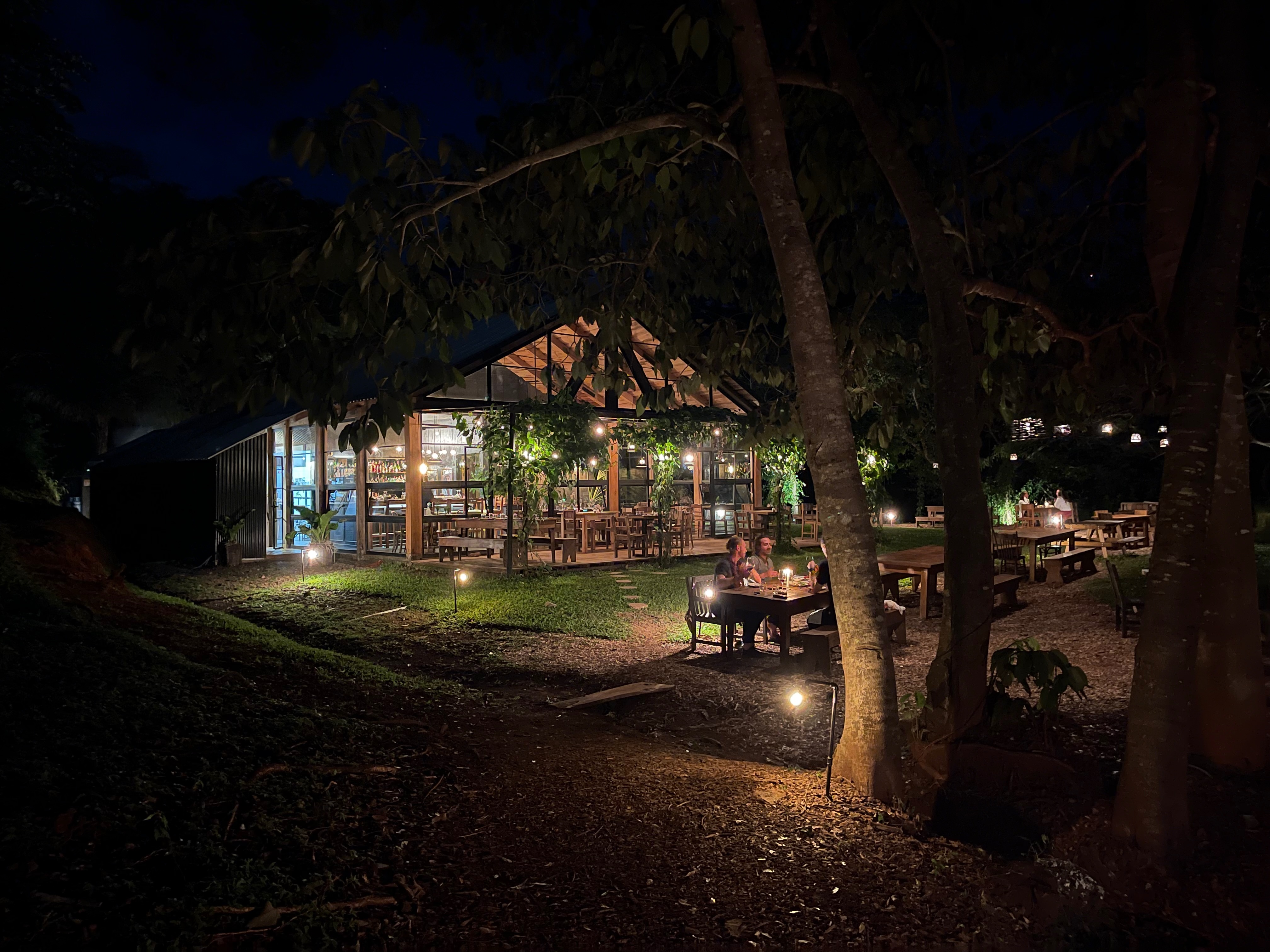 Coyol restaurant at night with hanging lanterns and tropical trees in Nosara, Costa Rica