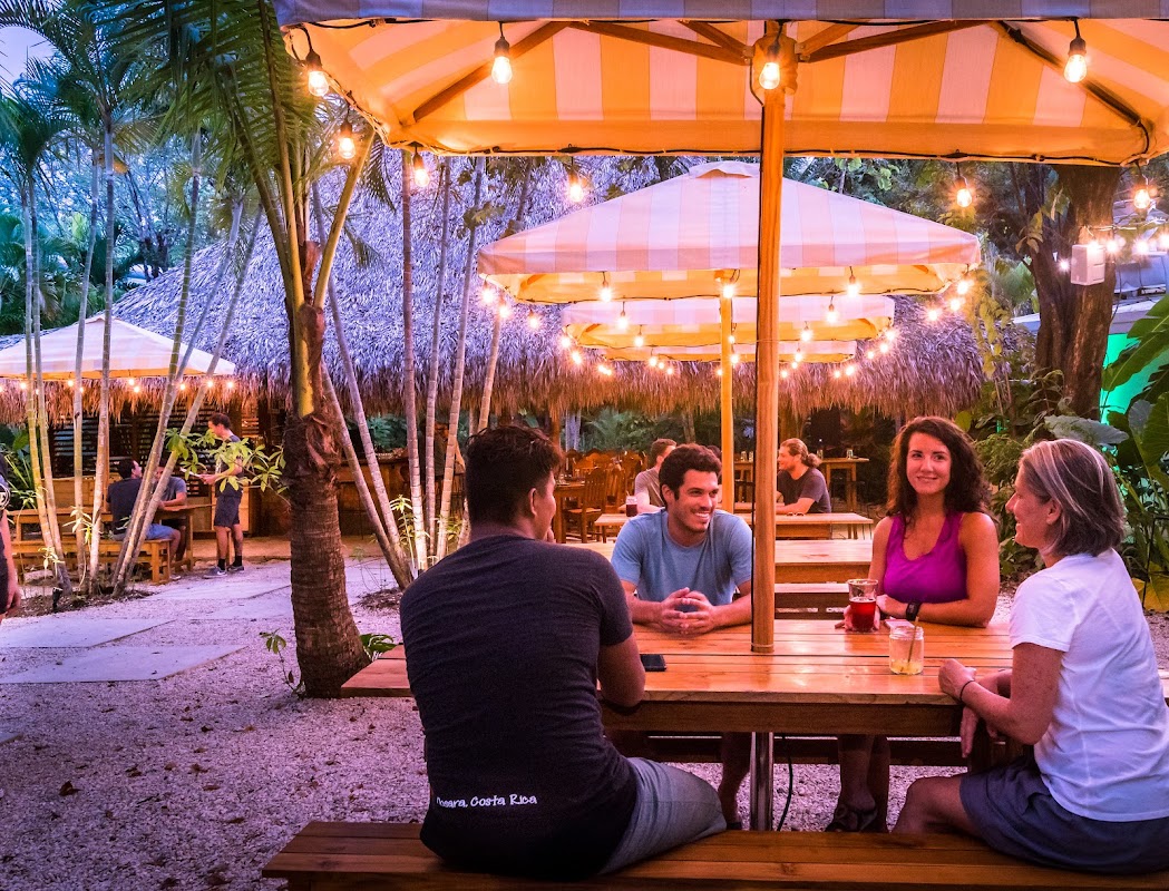 Al Chile outdoor dining area with string lights and palm trees at night in Nosara