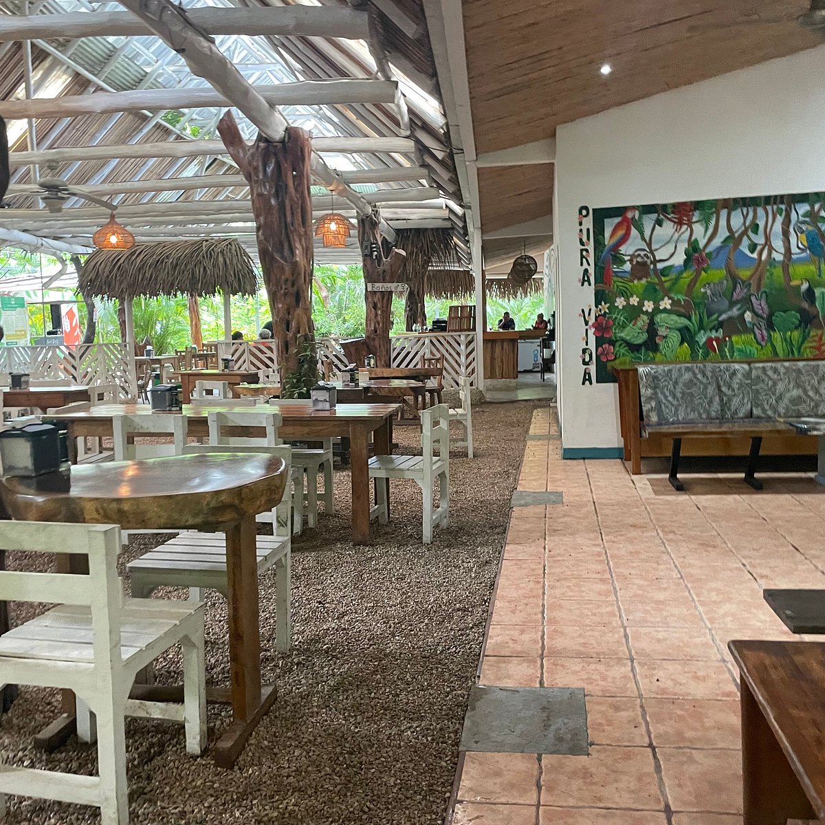 Il Pepperoni rustic thatched-roof dining area surrounded by tropical greenery