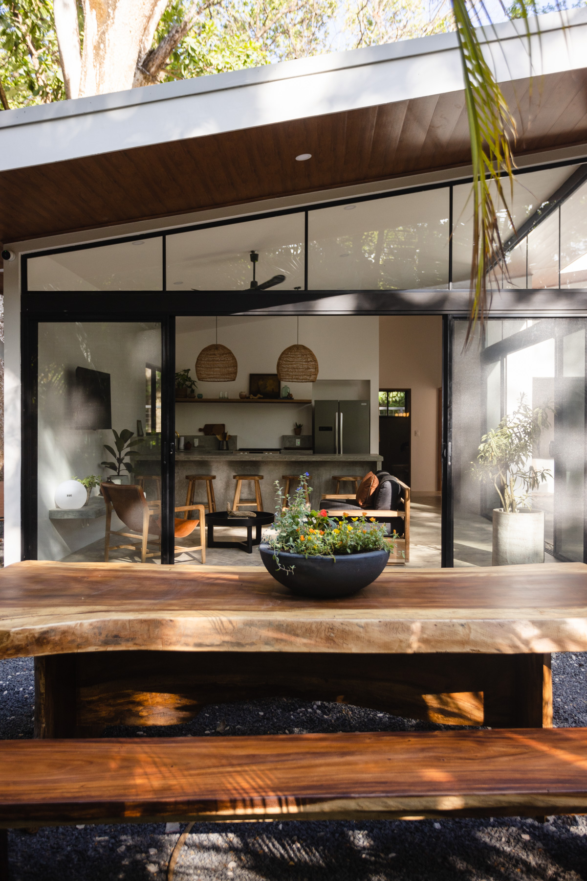 Indoor-outdoor living with glass doors open to jungle