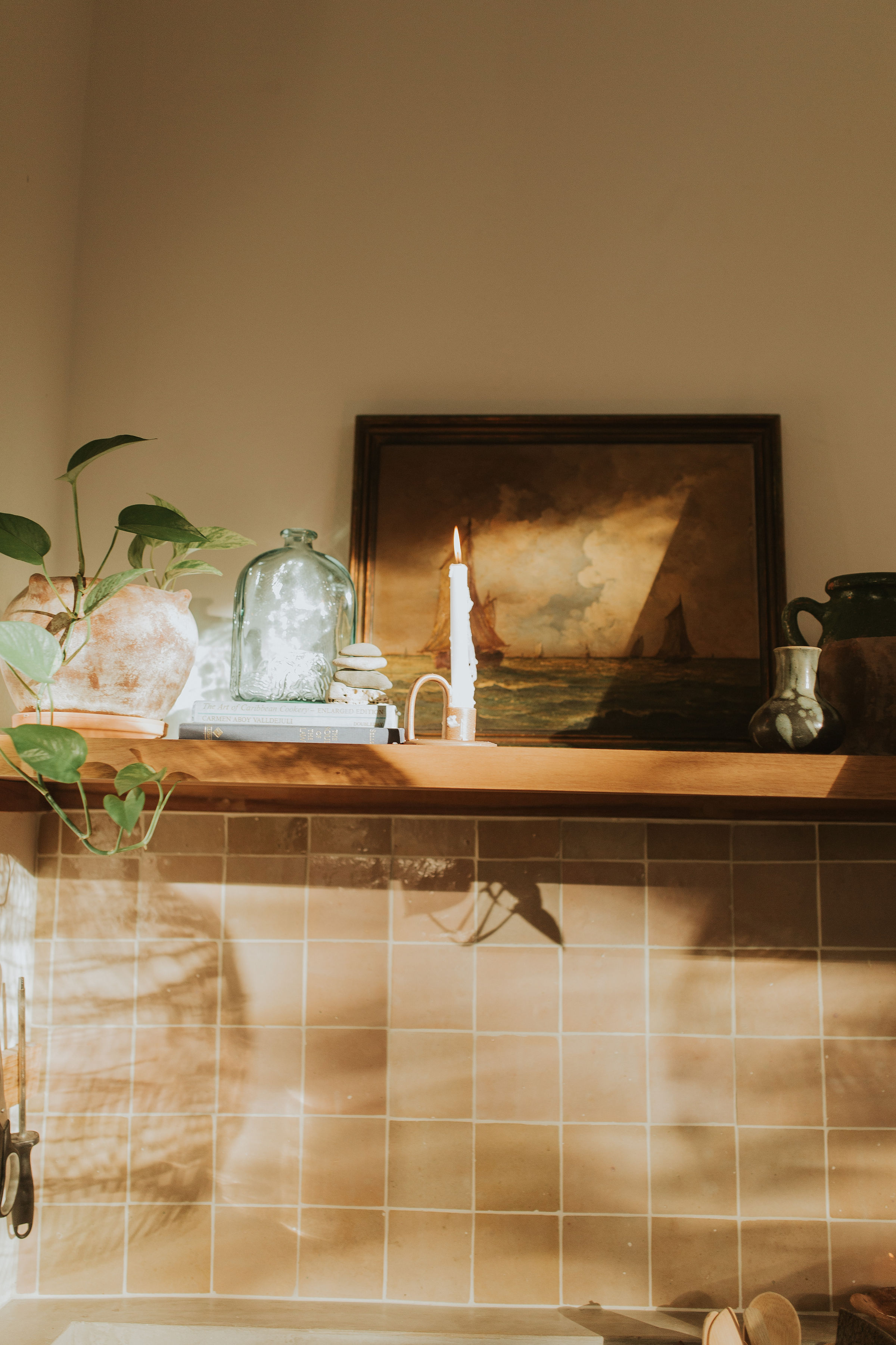 Kitchen shelf styling with vintage painting and candles