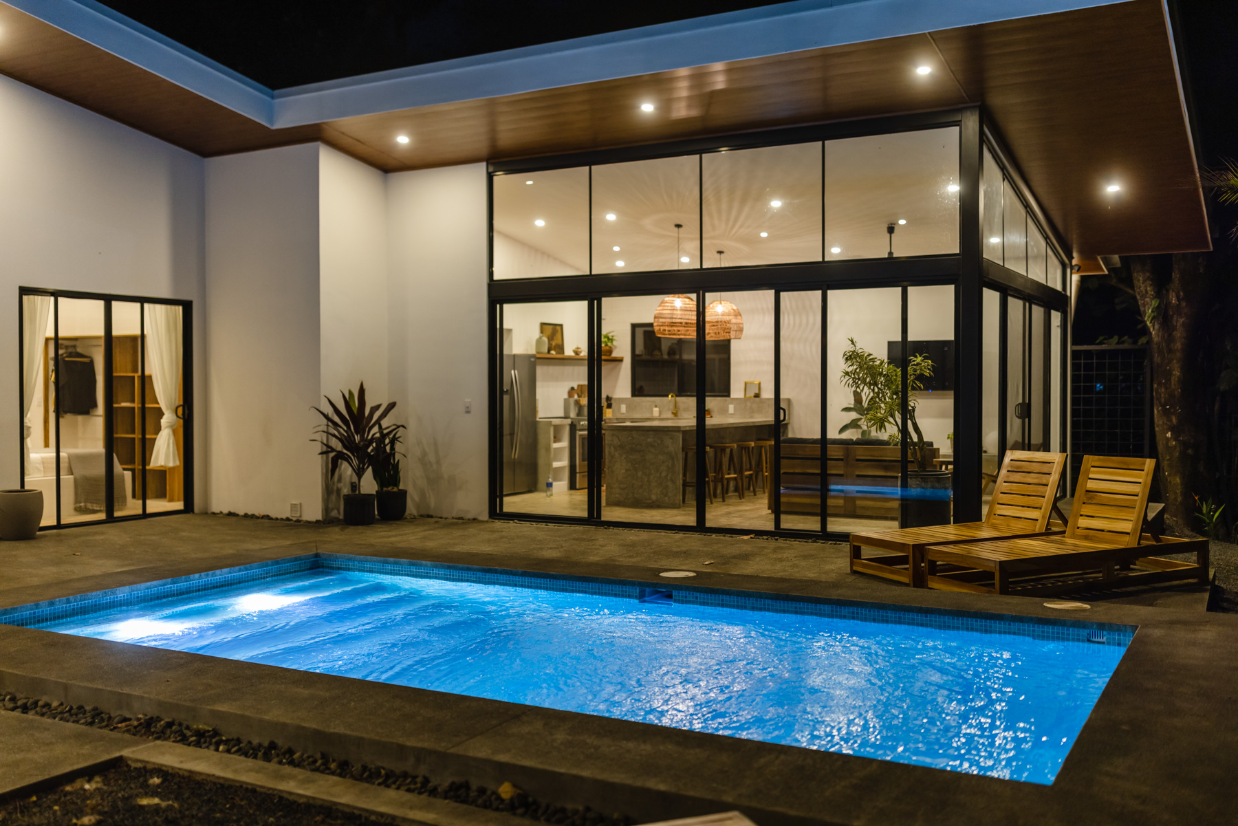 House glowing at twilight with illuminated pool