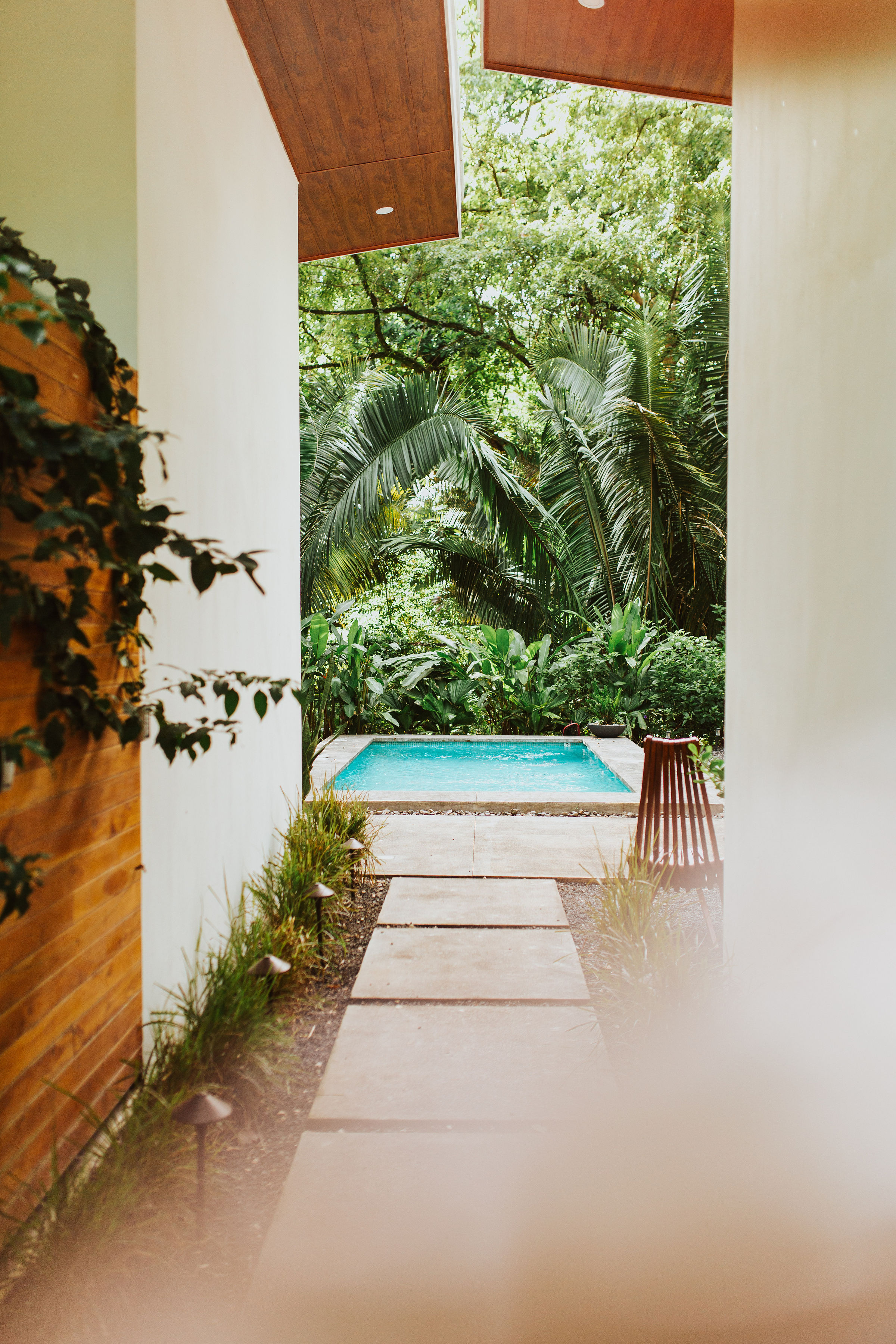 Stepping stone path between homes leading to turquoise pool